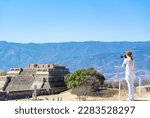 Small photo of Monte Alban, Oaxaca de Juarez, Mexico, 1st of January 2019, A female tourist tking a picture of the landscape of Monte Alban