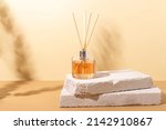 Small photo of reed diffuser bottle on the podium. Incense sticks for the home with a floral scent with hard shadows. The concept of eco-friendly fragrance for the home
