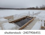 Small photo of a hole cut in the ice of a river or lake in winter, to bathe in icy water, to harden oneself, to prepare for Epiphany