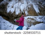 nice and active senior woman hiking in snowy and ice covered Eistobel Canyon in the Allgau alps near Gruenenbach, Bavaria, Germany
