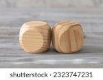 Small photo of Two abstract geometric wooden dice isolate on white rustic surface. Antagonism concept.