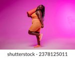Small photo of Active young voluptuous woman in sportswear carrying exercise mat and smiling on pink background