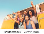 Young wild and free. Low angle view of group of young happy people having fun together while sitting inside of retro mini van 