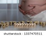 Small photo of Word ECLAMPSIA composed of wooden letters. Pregnant woman in the background