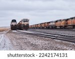 Small photo of Gillette, Wyoming - January 23, 2021: Trains on tracks on a cloudy cold winter day near Gillette, Wyoming.