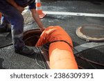 Small photo of Sewer repair. Pumping waste from hatch. Open hatch. Worker controls air supply. Sewerage accident.
