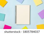 Spiral Notebook or Spring Notebook in Unlined Type and Multi Color Sticky Note on Blue Pastel Minimalist Background. Spiral Notebook Mockup on Center Frame