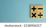 Small photo of mathematic concept.,Black color of mathematical operations or Plus, minus, multiply, divide symbols on wooden cube over blue pastel background with copyspace for put text or logo.