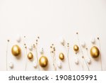 Small photo of Stylish golden eggs easter concept. Easter gold eggs with golden dried flax linum bunch white background. Flat lay trendy easter. Happy easter card. Copy space for text