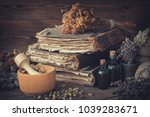 Tincture bottles, bunches of dry healthy herbs, stack of antique books, mortars, sack of medicinal herbs. Herbal medicine.