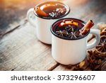 Mulled wine in white rustic mugs with spices and citrus fruit