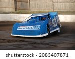 Small photo of Middletown, NY, USA - August 19, 2021: Short track racer Pancho Lawler steers his Dirt Late Model stock car around the dirt track at Orange County Fair Speedway.