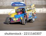 Small photo of Middletown, NY, USA - April 2, 2022: Short track racer Geoff Quackenbush hustles his Dirt Modified stock car around the dirt track at Orange County Fair Speedway. Car slightly blurred to depict speed.