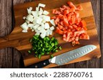 Small photo of Chopped Onion, Tomato, and Green Chili Pepper on a Wood Cutting Board: Prepped fresh vegetables on a wooden chopping board with a kitchen knife