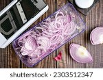 Red Onions Sliced Thinly with a Mandoline: Thinly sliced red onion and a mandoline viewed from directly above