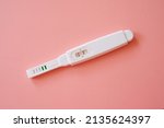 The positive pregnancy test isolated on pink background. Have baby. Test strip which shows the positive result. Health care concept. Top view, Flat lay.