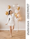 Small photo of Romantic happy european girl holding 30th birthday balloon