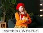 Small photo of Portrait schoolgirl holds two books. Girl wears bright outfit and woolen red beret. Concept of bookworm, bibliophile and International Children's Book Day