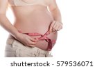 Small photo of Cute pregnant woman measuring belly. Uneventful pregnancy.