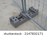 Concrete base with many holes for temporary portable fences for construction sites close up