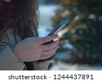 woman uses a smartphone on the street in winter