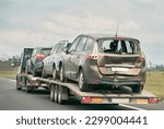 Small photo of Tow truck with broken car on country road. Tow truck transporting car on the highway. Car service transportation concept.