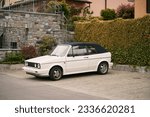 Small photo of White Retro Cabriolet, an Iconic 80s European Convertible, Graces the Open Road. Retro cabriolet. Convertible vehicle. White 80s European compact convertible hatchback car. Timeless Elegance