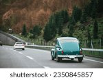 Vintage European Beauty in Motion. Blue Oldtimer Coupe Speeding Along the Public Highway. Old vintage European car model on the streets.