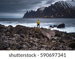 Lonely adventurer is amazed by the breathtaking view on rugged peak of mountain on Senja island, Norway