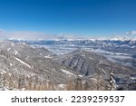 Panoramic view of the snowcapped mountain ranges of the Nock Mountains (Nockberge) seen from Kobesnock near Bad Bleiberg, Carinthia, Austria, Europe. Fog covered valley winter wonderland landscape