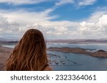Small photo of Rear view of woman with scenic view from Lake Mead Lakeview Overlook near Hoover Dam with turquoise water surrounded by River mountain range, Nevada Arizona, USA. Lake Mead National Recreation Area