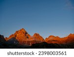 Scenic sunrise view of  mountain summit Monte Viso (Monviso) in the Cottian Alps, Piemonte, Italy, Europe. The rock walls of the Stone king are shining in warm red orange colors. Majestic landscape