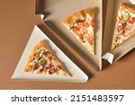 a slice of pizza in a triangle-shaped carton for serving and taking away