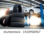 Small photo of new tires that change tires in the auto repair service center, blurred background, the background is a new car in the stock blur for the industry, a four-wheeled tire set at a large warehouse