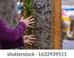 Small photo of Closeup image of senior person doing creative wampum decoration with green plants on yellow strings during world and spoken word festival