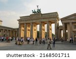 Small photo of Berlin, Germany - July 2010: View of Brandenburg gate or Brandenburger Tor in summer with crowd of people. Quadriga statue on top and clouds in blue sunset sky background.
