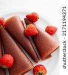 Small photo of Pastille strawberry rolls. Fruit leather in slices (pastila). Raw food, vegan sweetness, dessert without sugar and flour. Colorful fruit leather rolls with strawberry on white background.