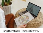 Small photo of Tver, Russia-august 7, 2022. A woman with a laptop is studying human design. The concept of studying esoteric sciences. Studying rave postcards from human design.