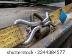 Cargo ratchet straps with metal hooks on the side of a flat bed truck used to secure heavy loads in order to transport them safely