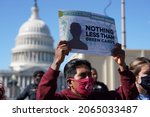 Small photo of Washington, DC â€“ October 27, 2021: A protester at the Capitol holds up an enlarged Green Card demanding the issuance of the important document to immigrants creating a road to citizenship.