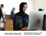 Small photo of Real Arab woman at office wearing Abaya Hijab with workmate colleagues employees people around. Middle East, UAE, Saudi Arabia, Qatar, Bahrain, Oman, Kuwait concept mock up for business or school