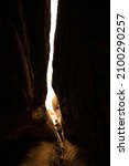 Small photo of Hiker Carefully Crossing The Precarious Passage Way In Slot Canyon Cave