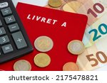 Small photo of Clamart, France - July, 6, 2022: Livret A with euro cash and a calculator. The Livret A is a regulated French savings account whose interest rate and deposit limit are defined by the government