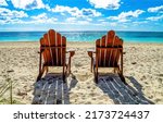 Two beach chairs on a sandy...