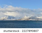 Snow-covered mountains with clouds, Risøyhamn with bridge, Andfjord, Andøya Island, Vesterålen, Nordland, Norway