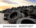 Landfill with old tires and tyres for recycling. Reuse of the waste rubber tyres. Disposal of waste tires. Worn out wheels for recycling. Tyre dump burning plant. Regenerated tire rubber produced. 