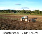 Small photo of Cultivated land and soil tillage. Tractor with disc cultivator on land cultivating. Agricultural tractor on cultivation field. Tractor disk harrow on plowing field. Soil cultivation, Plough plowed.