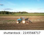 Small photo of Tactor with disk harrow on plowing field. Cultivated land and soil tillage. Tractor with disc cultivator on land cultivating. Agricultural tractor on soil cultivation field. Plough plowed.