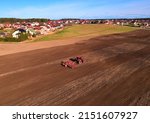 Tractor with cultivator plowing field. Tractor disk harrow on ploughing a soil. Planting in farmland. Sowing seed on plowed field. Seeding in agriculture. Farm Machinery for cultivating. Tractor plow.