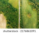 Highway through forest with pine trees and lakes, aerial view. Road with forrest trees and car. Forest road for transpotrs. Aerial above view of freeway. Asphalt road, top view.